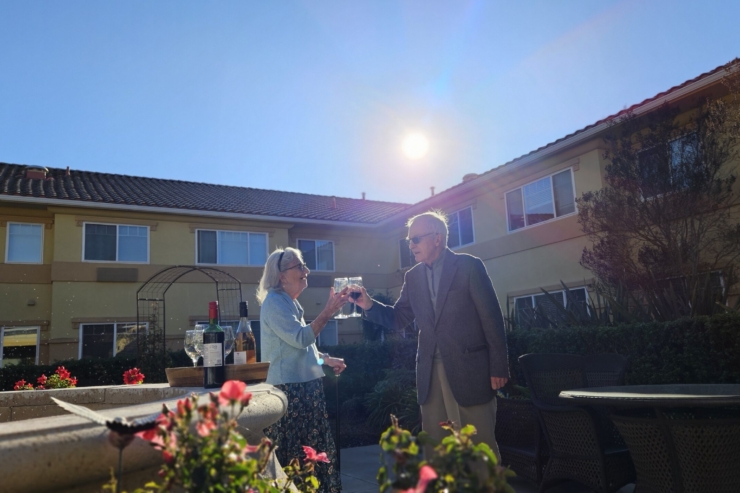 Seniors celebrate together in a vibrant garden, sharing joy and camaraderie under the sun.