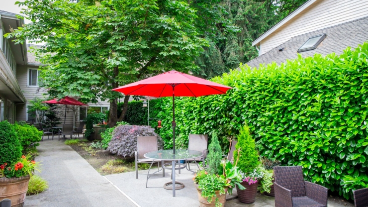 A welcoming garden space adorned with vibrant flowers and shaded seating invites relaxation and community.