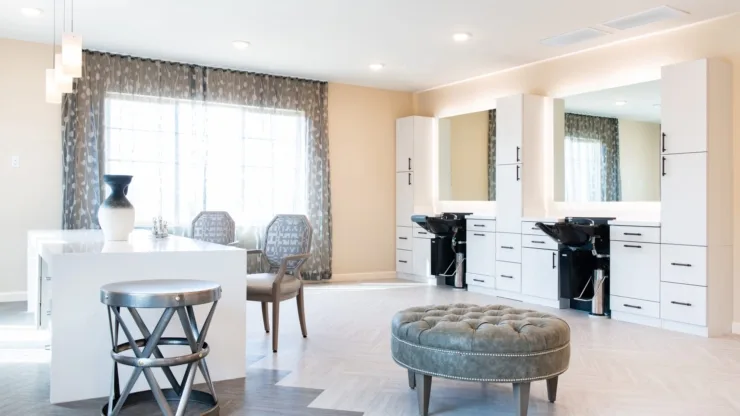 Bright, stylish salon space invites relaxation and community, with comfortable seating and elegant decor.