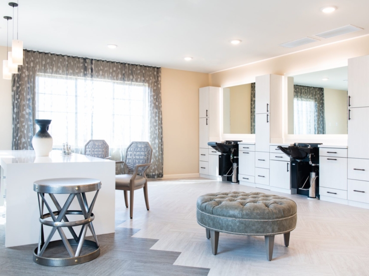 Bright, stylish salon space invites relaxation and community, with comfortable seating and elegant decor.
