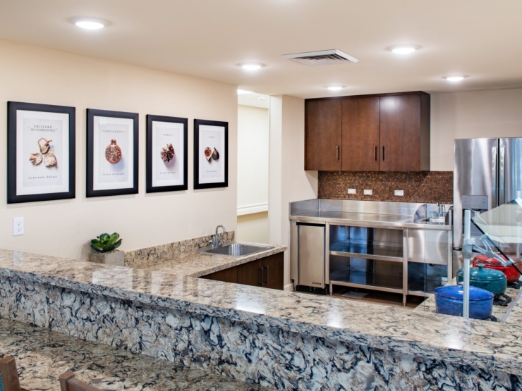 A bright, inviting kitchen space featuring warm colors and framed food art, perfect for community gatherings.