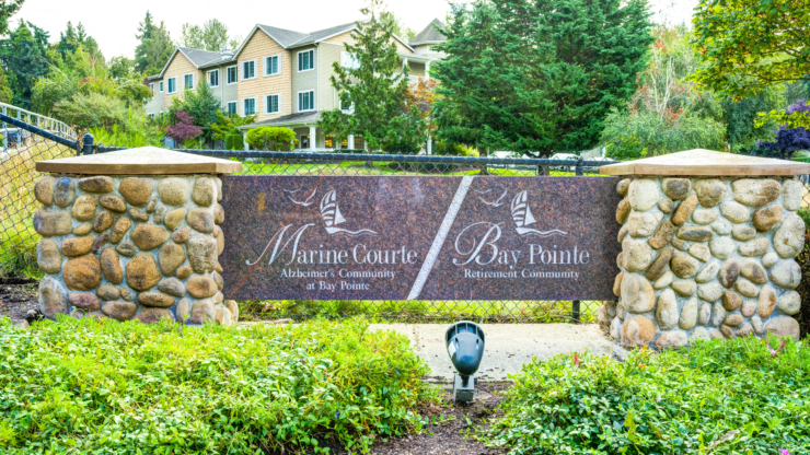 A welcoming entrance with lush greenery and a charming sign promotes community and tranquility.