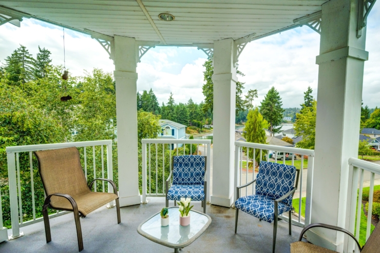 A cozy balcony with inviting seating, surrounded by lush greenery, perfect for relaxation and connection.