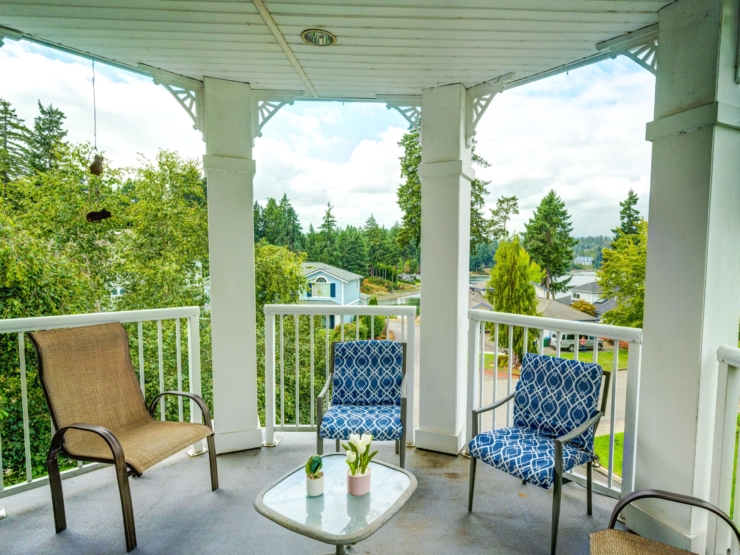 A cozy balcony with inviting seating, surrounded by lush greenery, perfect for relaxation and connection.