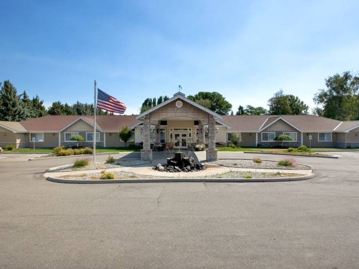 A welcoming entrance featuring a charming fountain and beautiful landscaping, perfect for community gatherings.