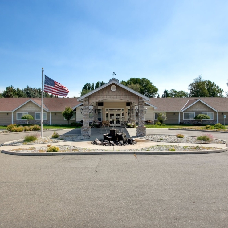 A welcoming entrance featuring a charming fountain and beautiful landscaping, perfect for community gatherings.