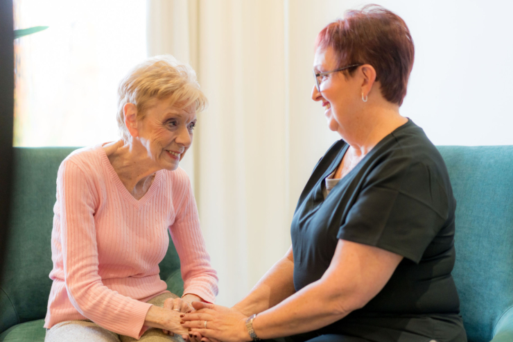 Two women share a warm conversation, fostering connection and comfort in a bright, welcoming space.