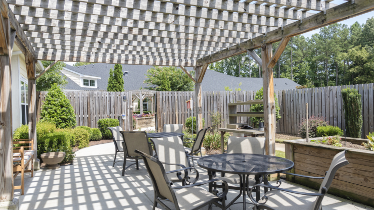A serene outdoor space with shaded seating invites relaxation and community gatherings in a lush garden setting.