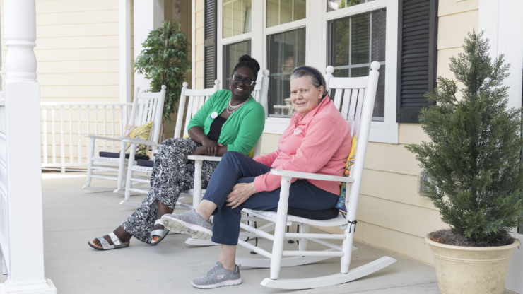 Warm smiles and friendly conversation on a welcoming porch, embodying community and comfort.