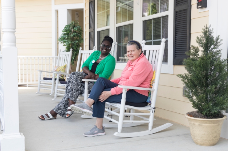 Warm smiles and friendly conversation on a welcoming porch, embodying community and comfort.