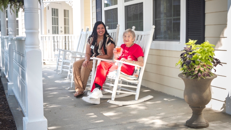 A warm, inviting porch scene where residents enjoy friendly conversations and companionship.
