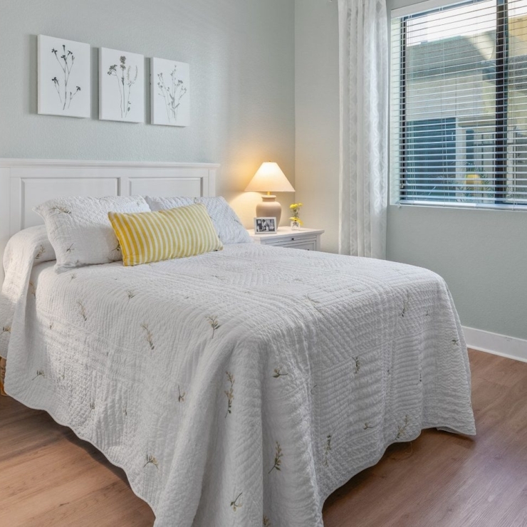 A serene bedroom filled with natural light, offering a welcoming atmosphere for relaxation and community.