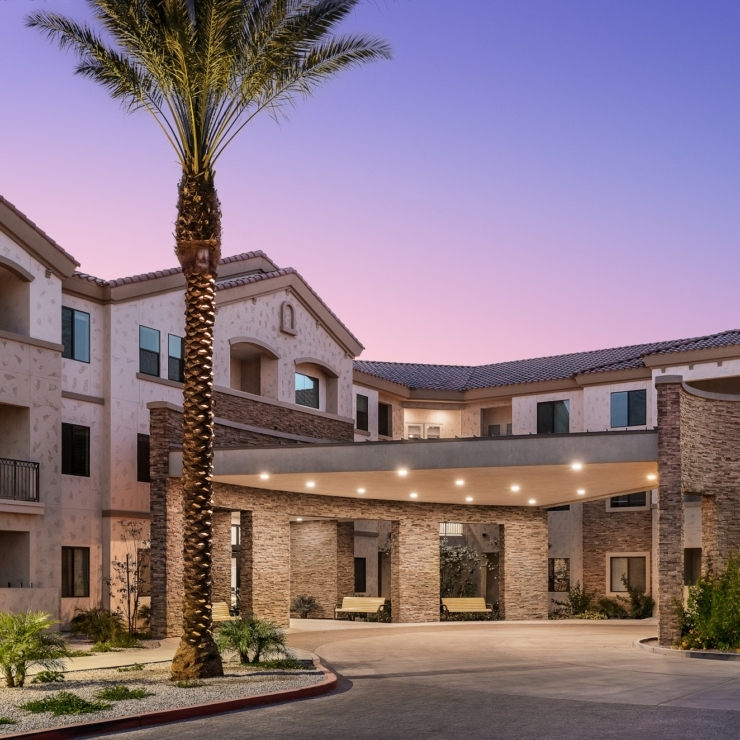 A welcoming entrance surrounded by palm trees, inviting residents to enjoy a vibrant community.