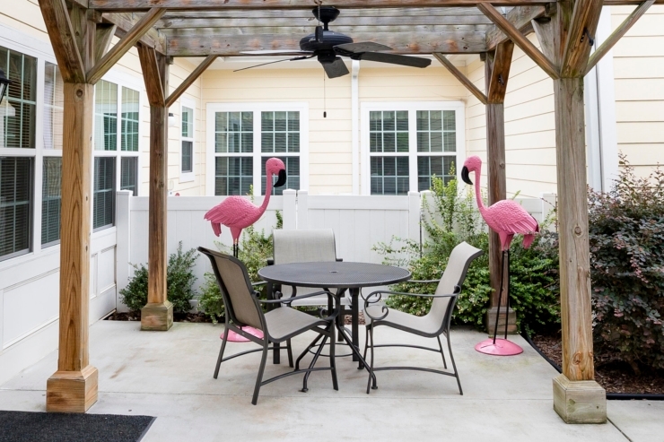 A welcoming patio with vibrant flamingo decor invites relaxation and social connection among residents.