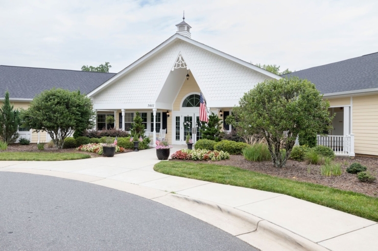 A welcoming entrance adorned with vibrant gardens, inviting residents to join a warm community.