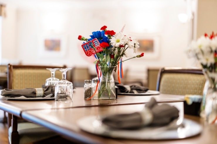 A welcoming dining setup adorned with vibrant flowers, inviting community and shared moments.