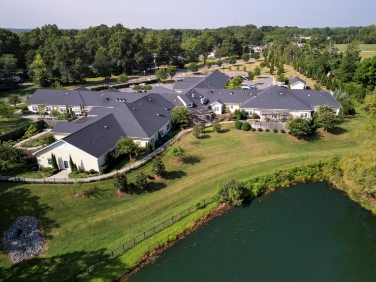 A serene lakeside community, surrounded by lush greenery, fostering connection and comfort.