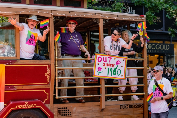 Celebrating vibrant community spirit, joyful faces wave from a decorated float at a lively parade.