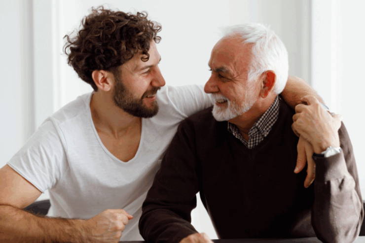 Two gentlemen share a joyful moment, fostering warmth and connection in a welcoming, bright setting.