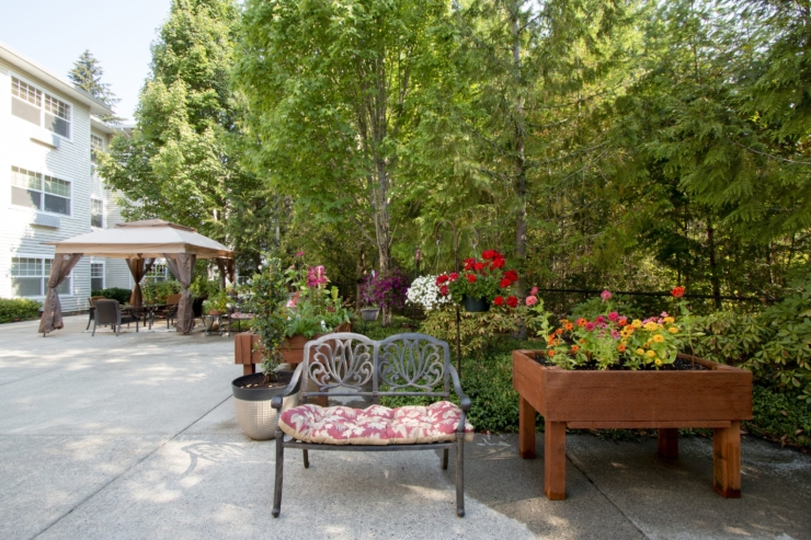 A serene garden space with vibrant flowers and cozy seating invites relaxation and community connection.