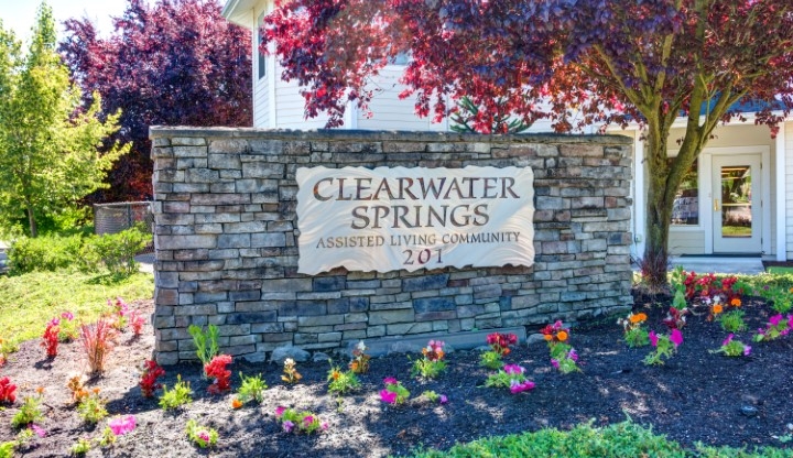Welcoming entrance to Clearwater Springs, featuring vibrant flowers and a warm community atmosphere.