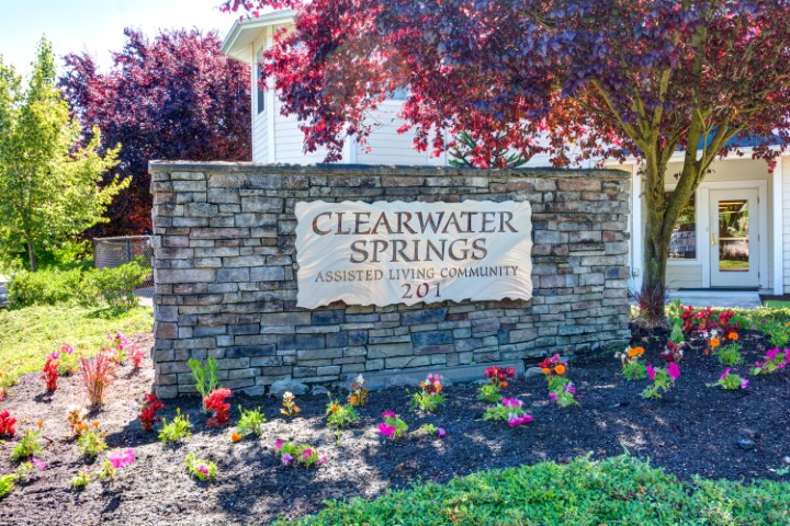 Welcoming entrance to Clearwater Springs, featuring vibrant flowers and a warm community atmosphere.