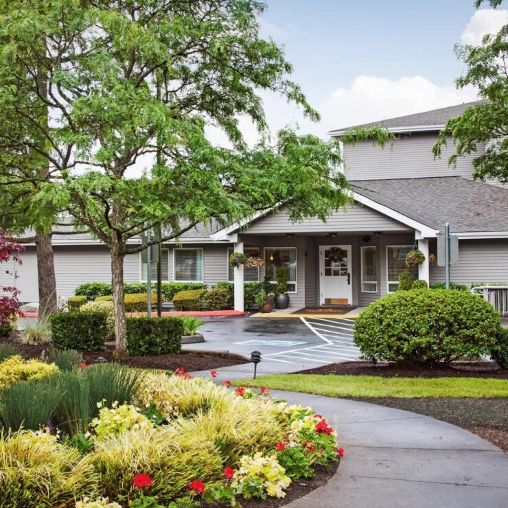 Welcoming entrance surrounded by vibrant gardens, fostering community and comfort for all residents.