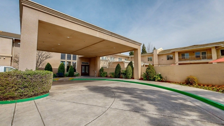 Welcoming entrance surrounded by lush greenery, creating a warm, community-focused atmosphere.