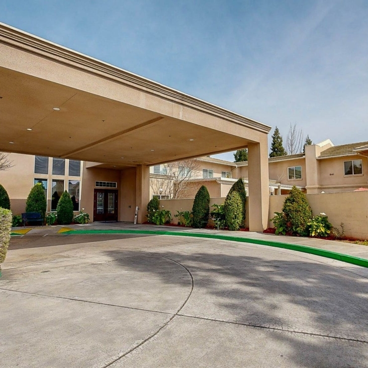 Welcoming entrance surrounded by lush greenery, creating a warm, community-focused atmosphere.