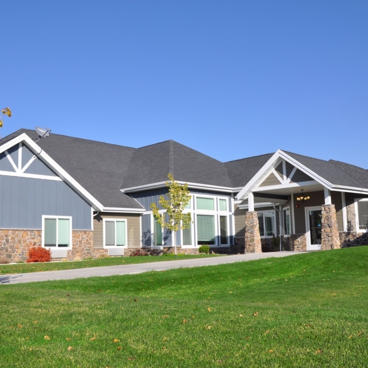 A warm, inviting community space surrounded by lush greenery and bright blue skies.