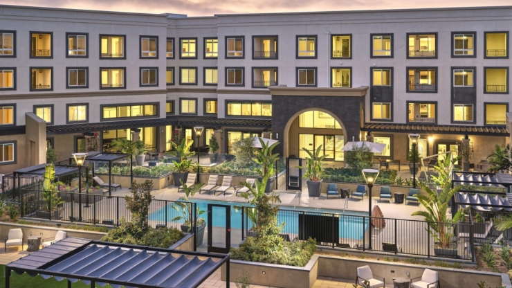 An inviting outdoor space with a serene pool and lush greenery, perfect for community gatherings.