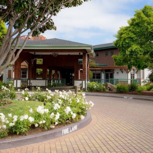 A welcoming entrance surrounded by vibrant flowers and greenery, inviting a sense of community and comfort.
