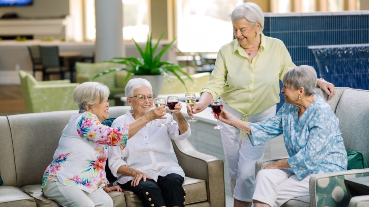 Four friends share a joyful toast in a bright, welcoming lounge, celebrating companionship and happiness.