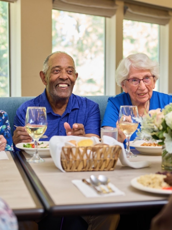 Lively conversation and smiles fill this welcoming dining area, fostering connection and comfort.