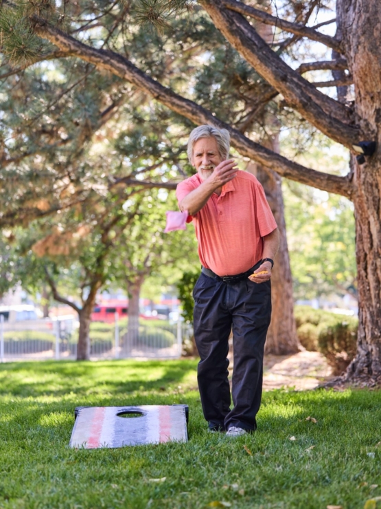 Engaging in friendly competition, a resident enjoys a sunny day outdoors, fostering connection and joy.
