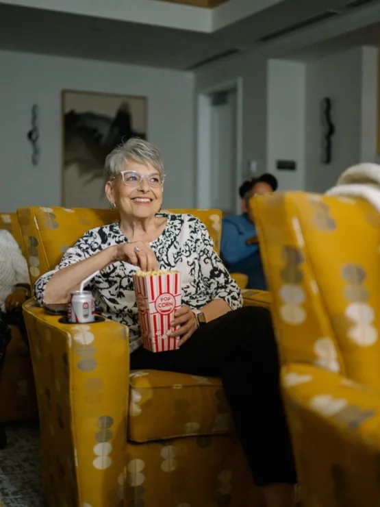 Residents enjoy a movie night, sharing laughter and popcorn in a welcoming, vibrant atmosphere.