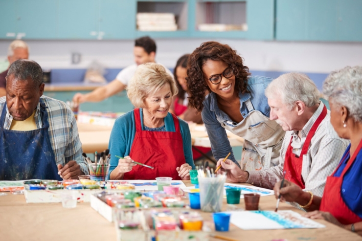 Seniors engage joyfully in art, fostering creativity and connection within a vibrant community.