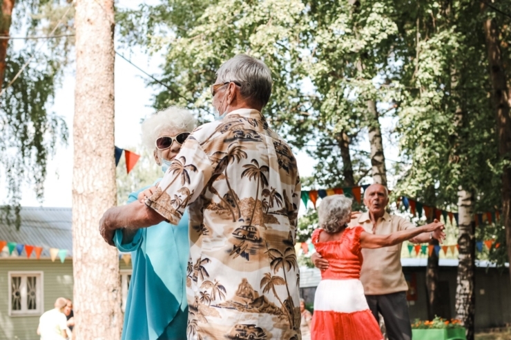 Joyful residents dance together under vibrant decorations, celebrating community and connection.