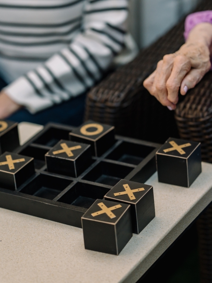 Engaging residents enjoy a friendly game of tic-tac-toe, fostering connection and joy.