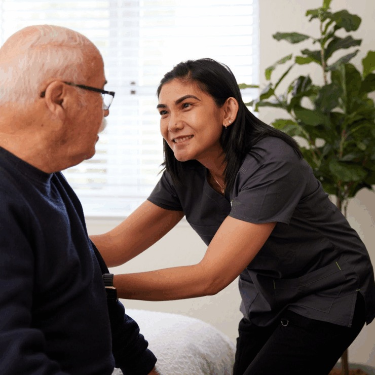 A warm interaction between a caregiver and resident, highlighting comfort and community in a cozy setting.