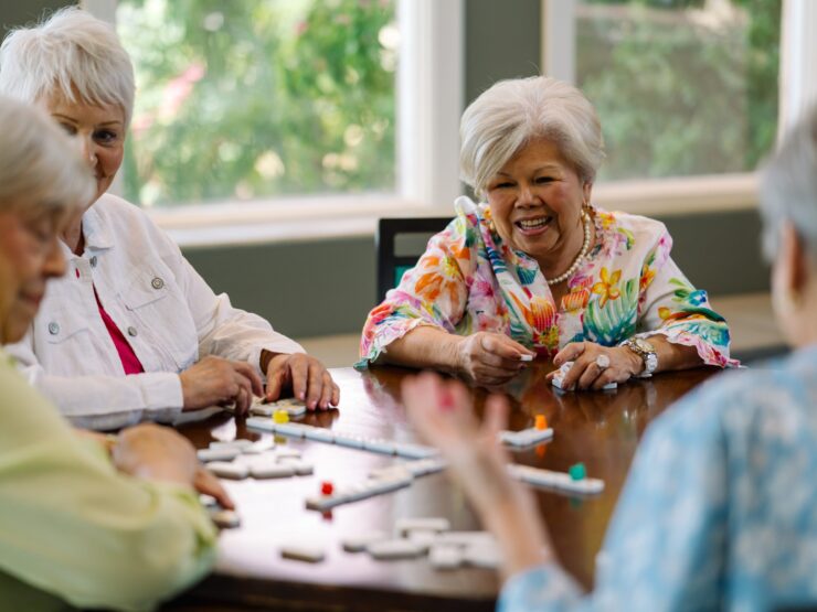 Engaging residents share laughter and stories around a bright, welcoming table, fostering community spirit.
