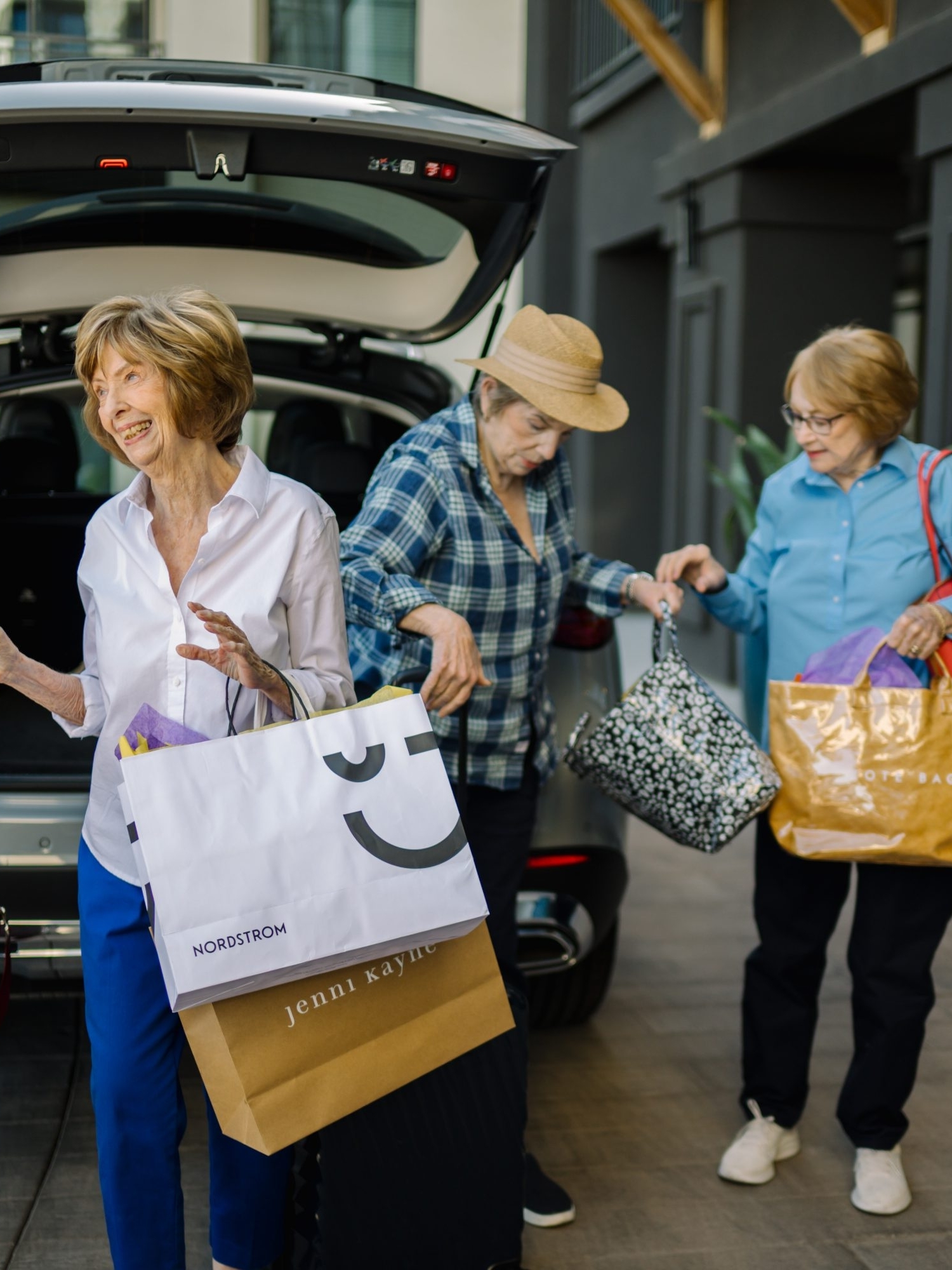 A lively group of friends shares laughter while unloading shopping bags, embodying community spirit and joy.