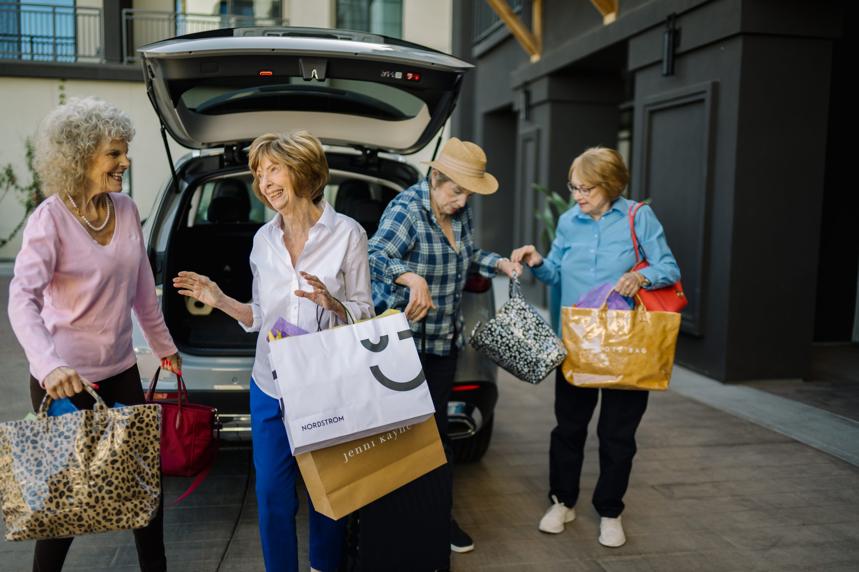 A lively group of friends shares laughter while unloading shopping bags, embodying community spirit and joy.