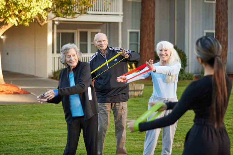 Seniors joyfully engage in stretching exercises, fostering community and wellness in a bright, inviting setting.