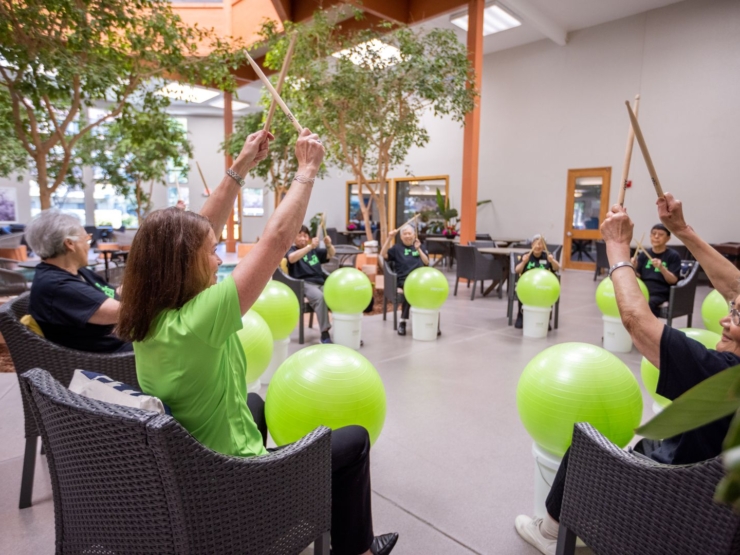 Residents engage joyfully in rhythmic activities, fostering connection and vitality in a vibrant setting.