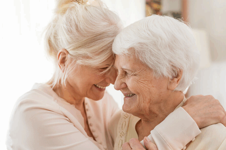 Two women share a joyful embrace, radiating warmth and connection in a cozy, inviting space.