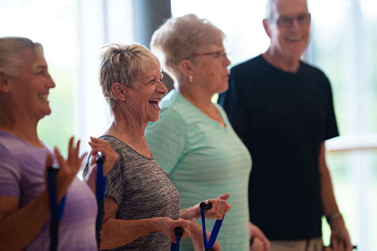 Lively seniors engage in a joyful fitness class, fostering camaraderie and enhancing well-being together.