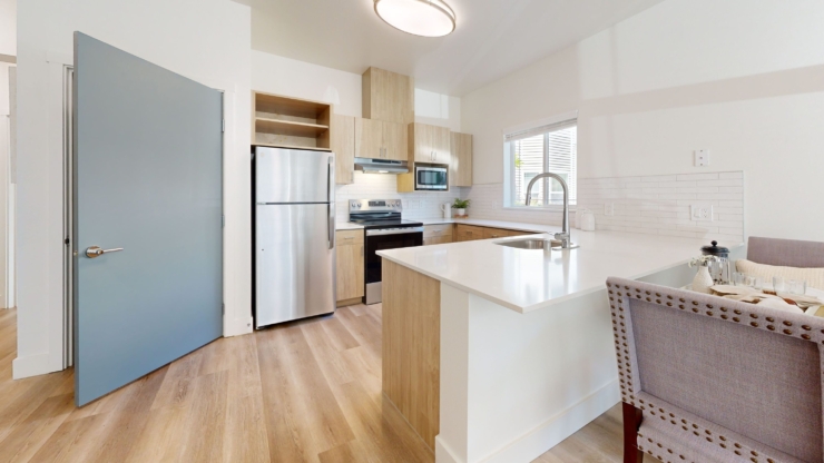 A bright, welcoming kitchen featuring modern appliances and inviting seating, perfect for community gatherings.
