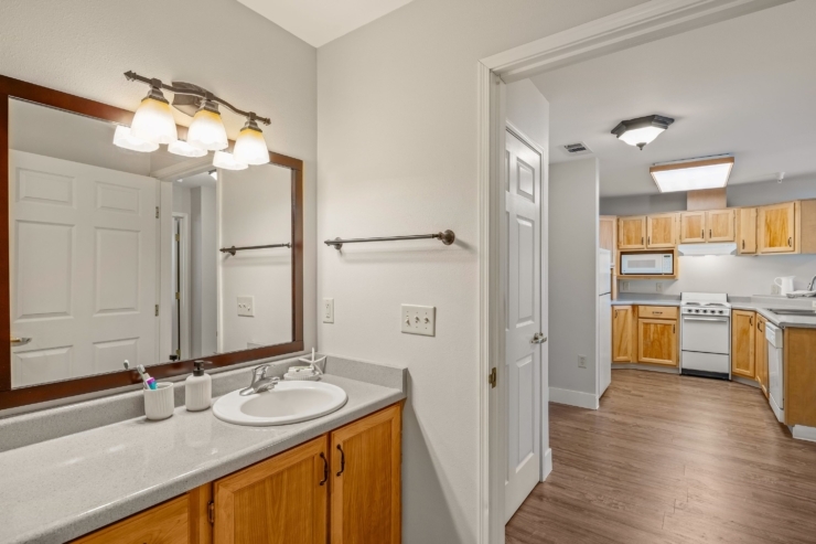 Bright and inviting bathroom leading to a warm kitchen, showcasing a welcoming community atmosphere.