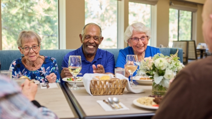 Lively dining scene with smiling residents enjoying a meal together, fostering community and warmth.